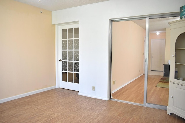 unfurnished bedroom with hardwood / wood-style floors, a closet, and a textured ceiling