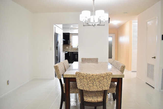 dining room featuring light tile patterned floors, sink, and a chandelier