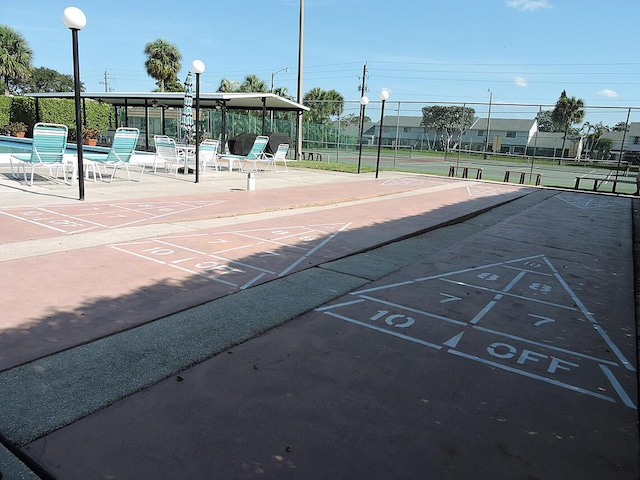 view of home's community featuring tennis court