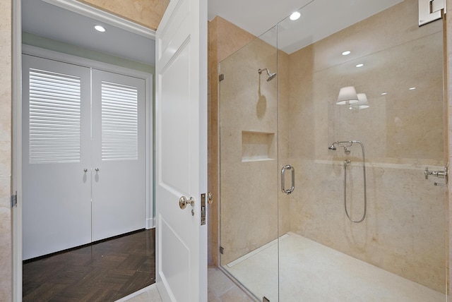 bathroom featuring an enclosed shower and parquet flooring