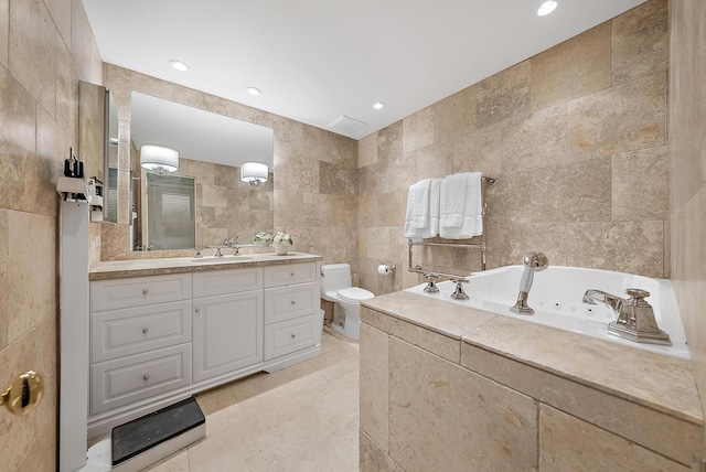 bathroom with vanity, a bath, tile patterned flooring, toilet, and tile walls