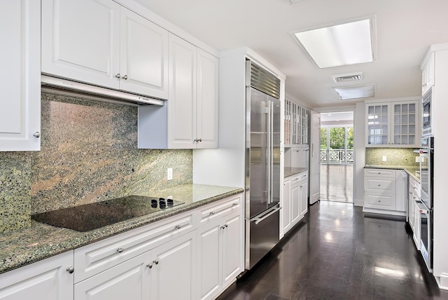 425 Worth Ave Unit 2F, Palm Beach, FL 33480 - kitchen featuring built in appliances, under cabinet range hood, decorative backsplash, white cabinets, and glass insert cabinets