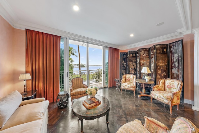 living room with decorative columns, a water view, and ornamental molding