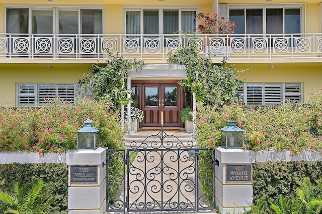 425 Worth Ave Unit 2F, Palm Beach, FL 33480 - view of exterior entry with a balcony, fence, and stucco siding