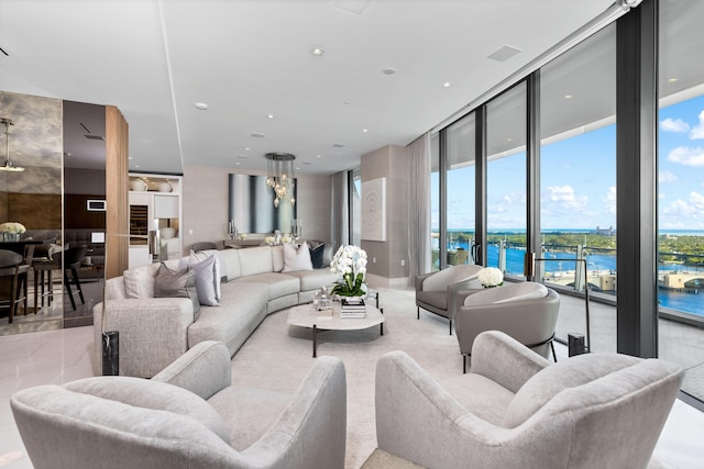 living room with a water view, a wealth of natural light, and a wall of windows