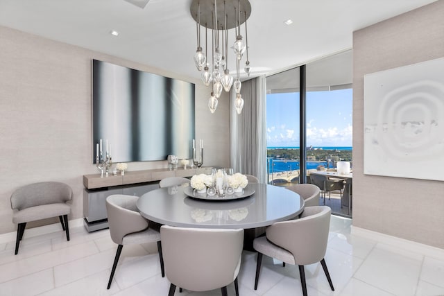 tiled dining area with a water view, a notable chandelier, and a wall of windows