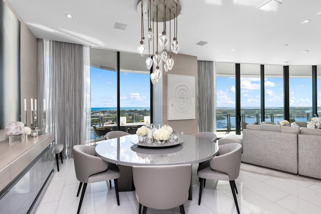 tiled dining room with a water view, a chandelier, plenty of natural light, and floor to ceiling windows