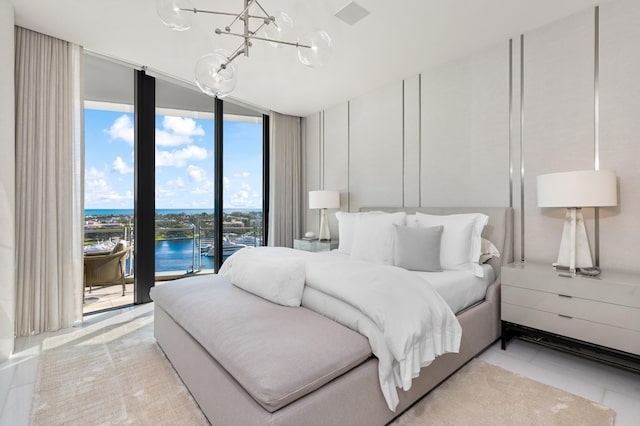 tiled bedroom featuring access to outside, a chandelier, a wall of windows, and a water view