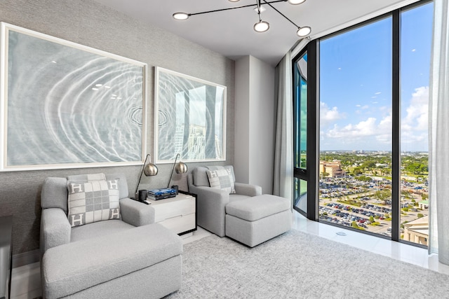 living room with a chandelier, a healthy amount of sunlight, and floor to ceiling windows