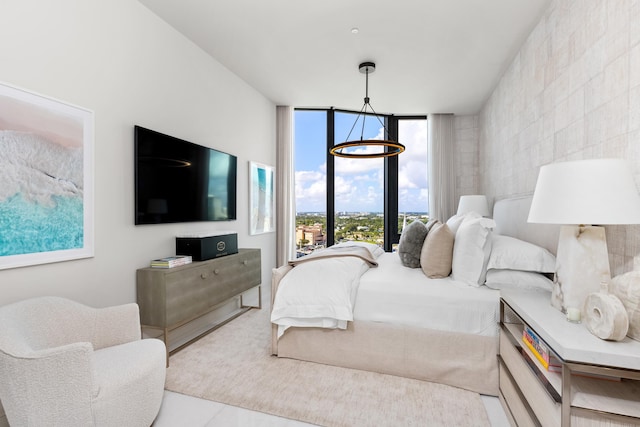 bedroom featuring a wall of windows and a chandelier