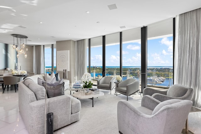 living room featuring an inviting chandelier, a water view, and a wealth of natural light