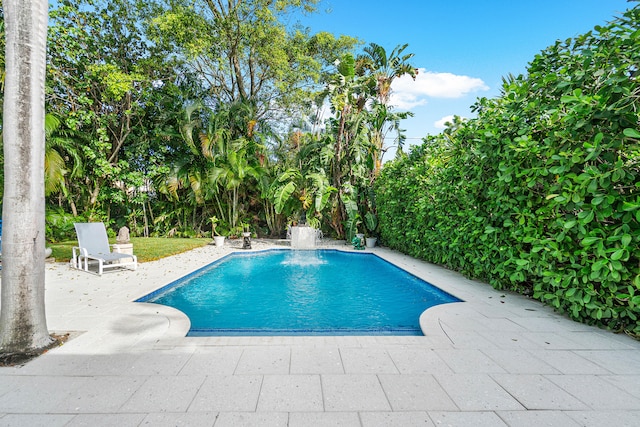 view of pool featuring pool water feature and a patio