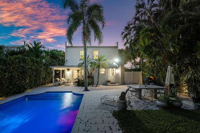 323 Dyer Rd, West Palm Beach, FL 33405 - pool at dusk featuring a patio and an outdoor pool