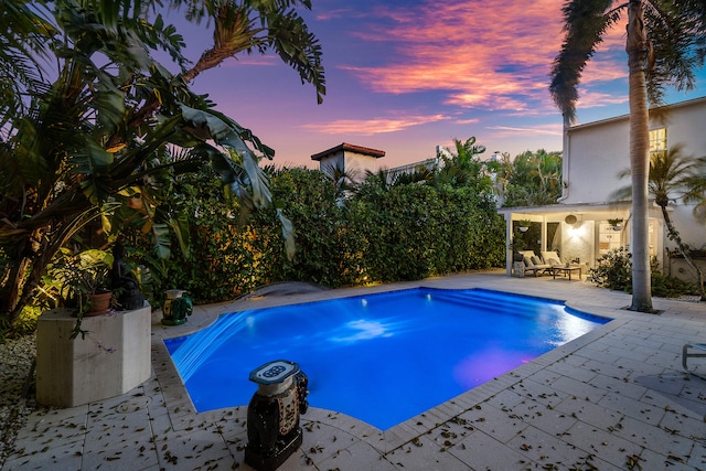 pool at dusk with a patio