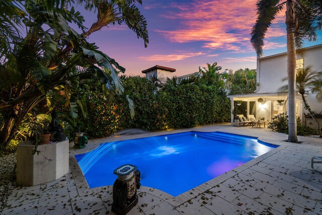 323 Dyer Rd, West Palm Beach, FL 33405 - pool at dusk featuring a patio area