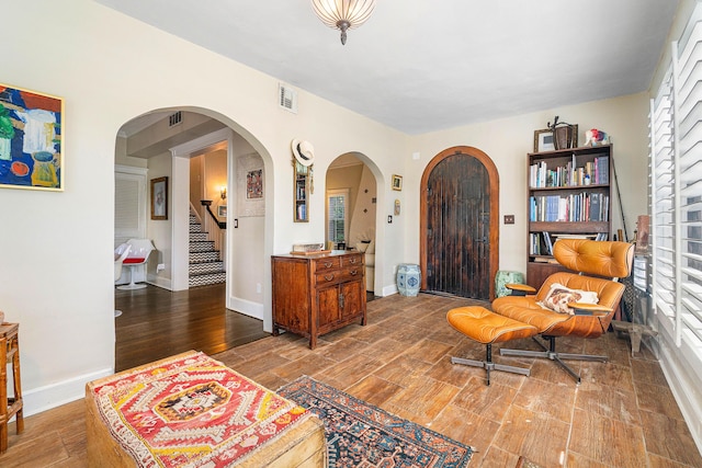 323 Dyer Rd, West Palm Beach, FL 33405 - sitting room featuring wood finished floors, arched walkways, stairway, and baseboards