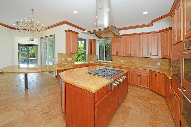 kitchen with stainless steel gas stovetop, a center island, plenty of natural light, and island range hood