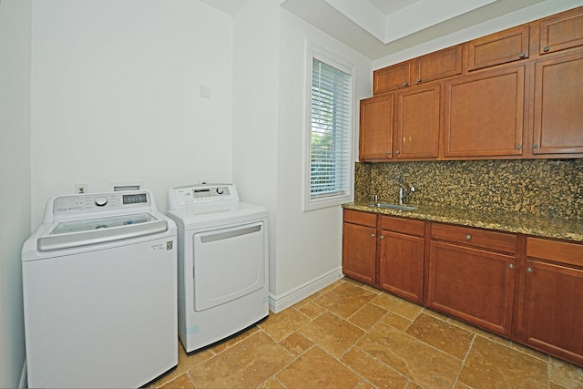 washroom featuring cabinets, sink, and washing machine and clothes dryer