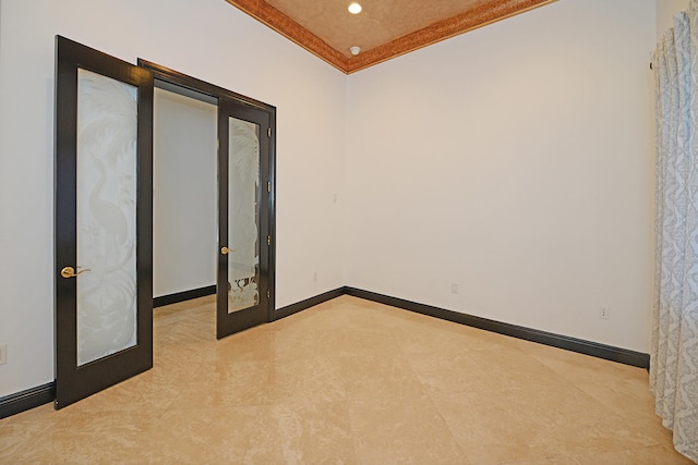 unfurnished room featuring crown molding, light tile patterned flooring, and french doors