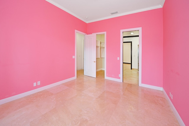 unfurnished bedroom featuring a spacious closet, a closet, and ornamental molding