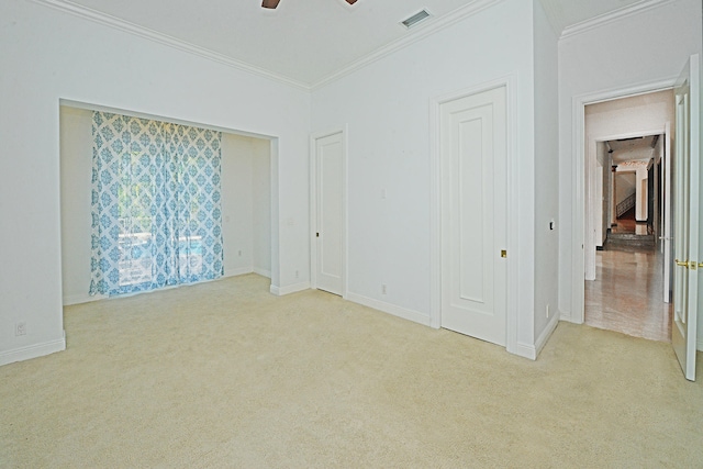 unfurnished bedroom with ornamental molding, light colored carpet, and ceiling fan