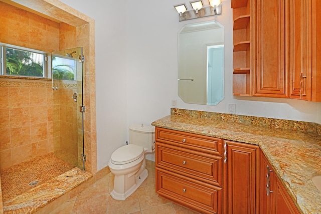 bathroom with toilet, vanity, tile patterned floors, and a shower with door