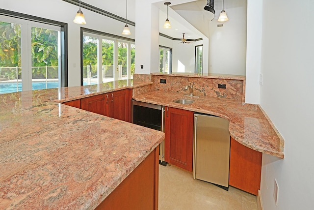 kitchen with sink, decorative light fixtures, light colored carpet, and stainless steel fridge