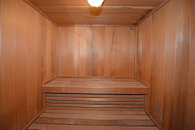 view of sauna featuring wood walls and wooden ceiling