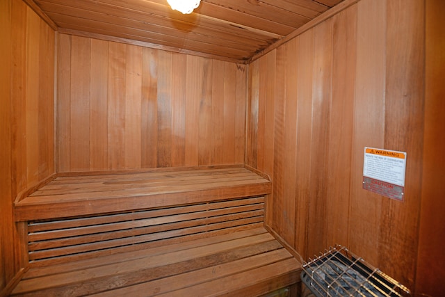 view of sauna with wooden ceiling and wooden walls