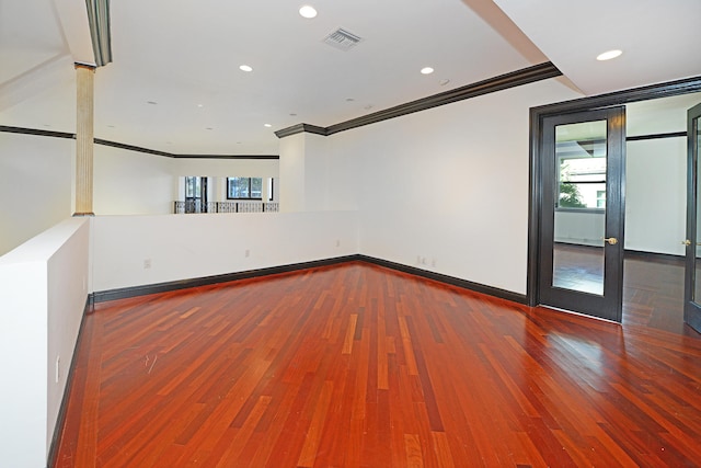 unfurnished room with ornamental molding and wood-type flooring