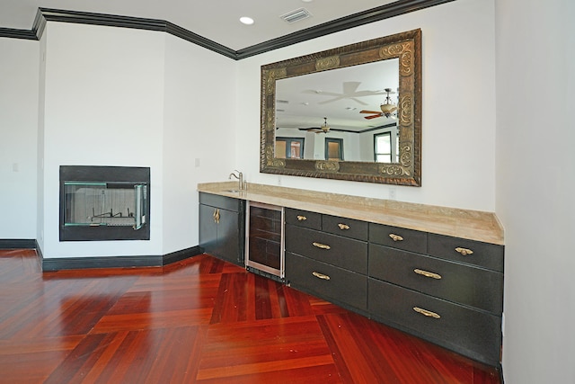 bar featuring crown molding, sink, dark parquet flooring, ceiling fan, and wine cooler