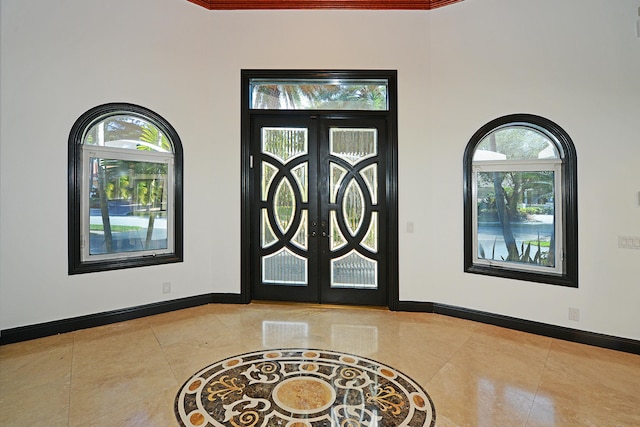 foyer featuring a towering ceiling, french doors, and tile patterned floors