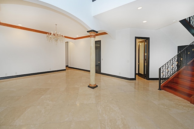 empty room featuring ornamental molding, decorative columns, and an inviting chandelier