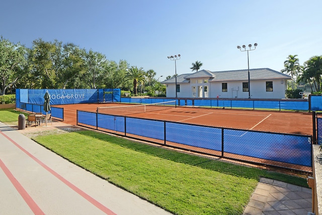 view of tennis court featuring a yard