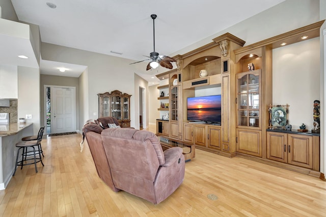 living room featuring ceiling fan, light hardwood / wood-style floors, and built in features