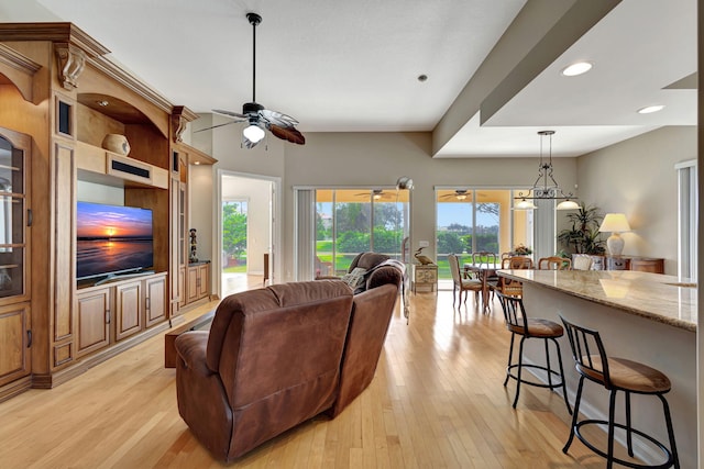 living room with light wood-type flooring, a ceiling fan, and recessed lighting