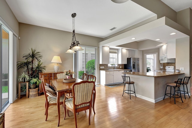 dining room with light hardwood / wood-style floors and sink