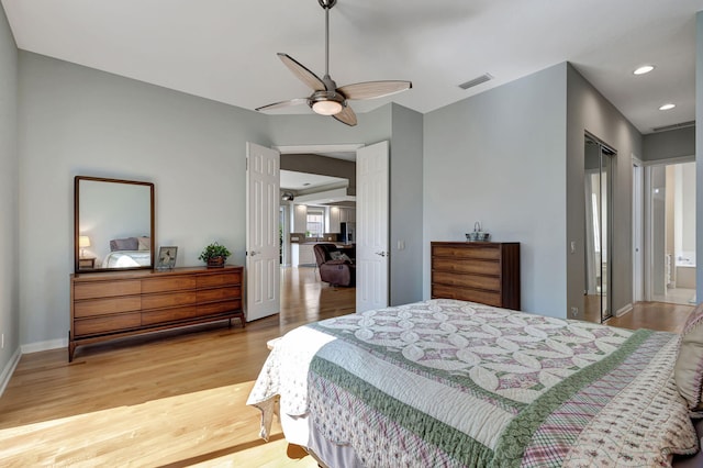 bedroom featuring ensuite bathroom, light hardwood / wood-style flooring, and ceiling fan