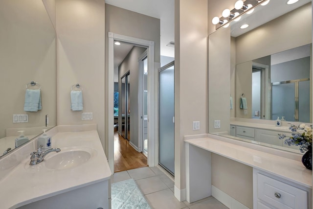 bathroom featuring vanity, tile patterned floors, and a shower with shower door