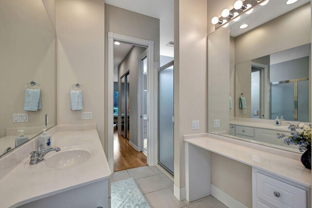 bathroom featuring tile patterned flooring, vanity, and a shower stall