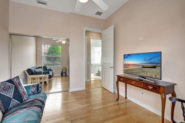 living room featuring ceiling fan, lofted ceiling, and light hardwood / wood-style flooring