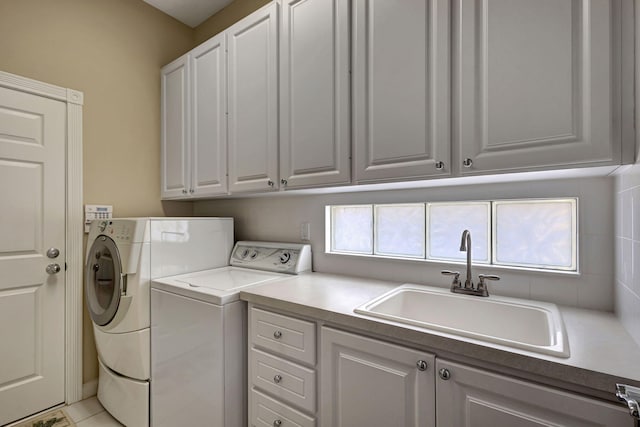 washroom featuring cabinets, light tile patterned floors, sink, and washing machine and clothes dryer