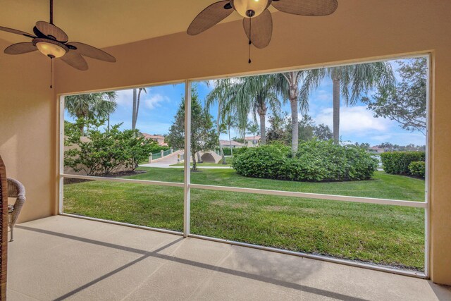 unfurnished sunroom featuring ceiling fan