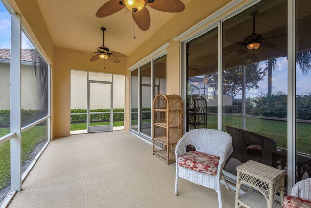 unfurnished sunroom featuring ceiling fan