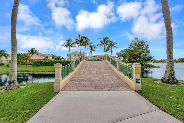 view of property's community with a water view and a yard