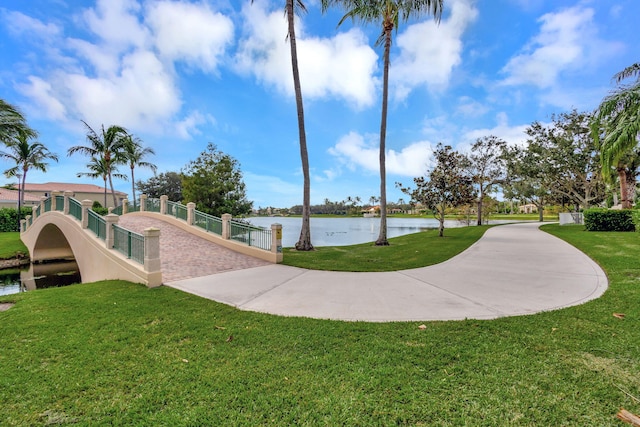 view of property's community featuring a water view, fence, and a yard