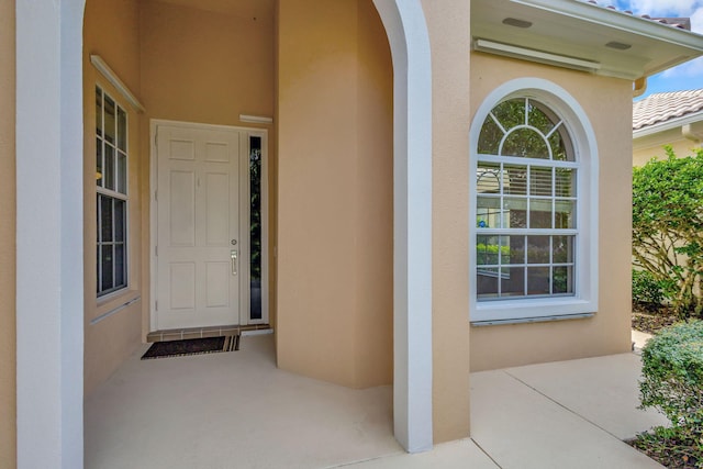 property entrance with stucco siding