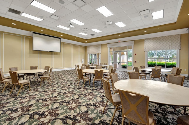 carpeted dining space with crown molding, a tray ceiling, and french doors