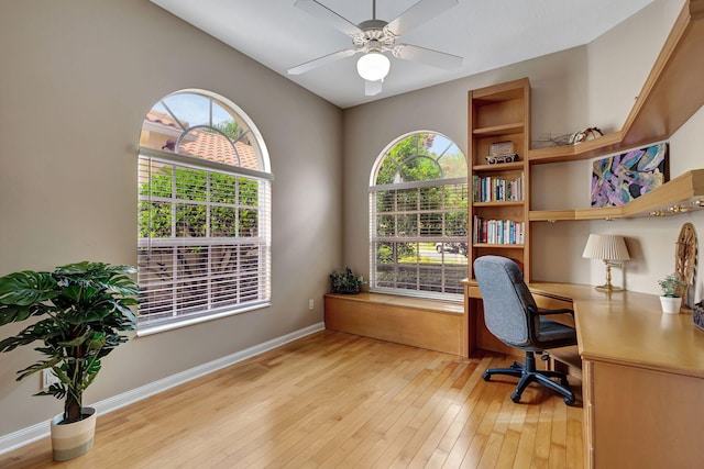 office space with light wood-style floors, baseboards, and a ceiling fan