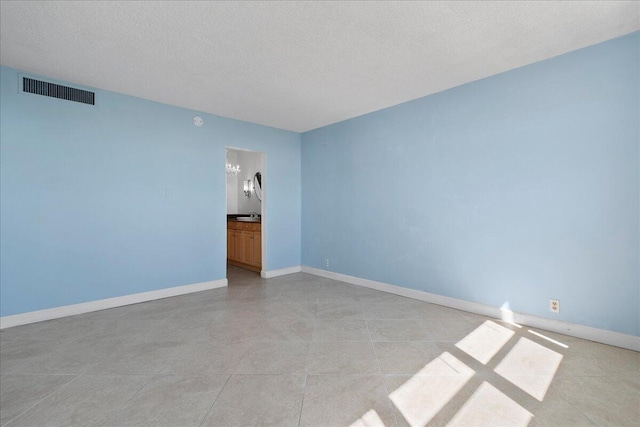 unfurnished room featuring a textured ceiling